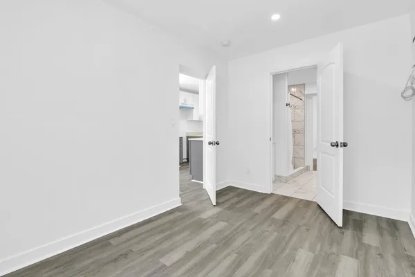 an empty room with wooden floor and entrance