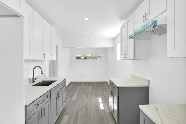 a kitchen with a sink cabinets and wooden floor