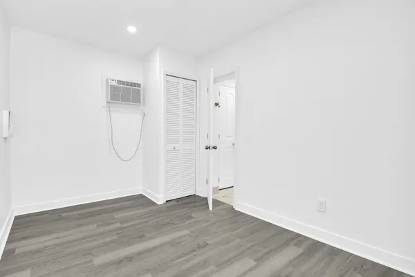 a view of a room with wooden floor and white walls