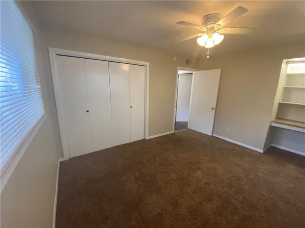 a view of a bedroom with closet and chandelier fan