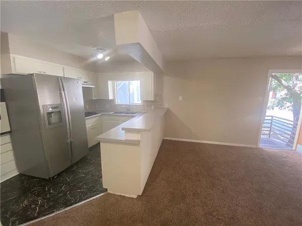 a view of a refrigerator in kitchen and entryway