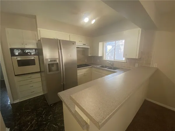 a kitchen with stainless steel appliances a refrigerator sink and stove