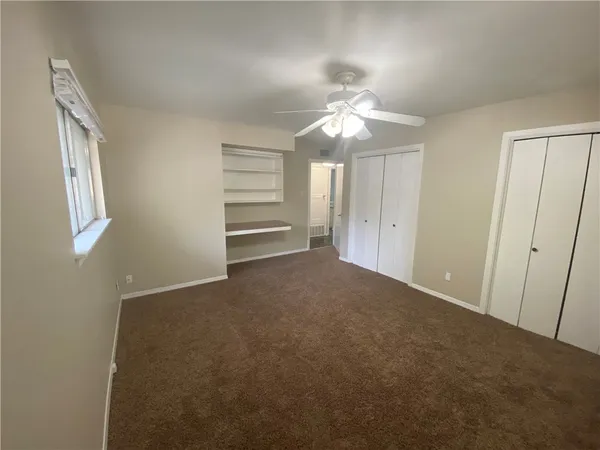 a view of an empty room with a chandelier fan