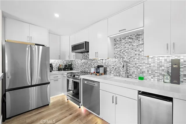 a kitchen with a sink appliances and cabinets
