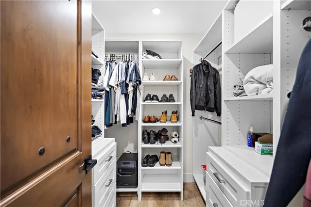 a view of walk in closet with clothes and shoes