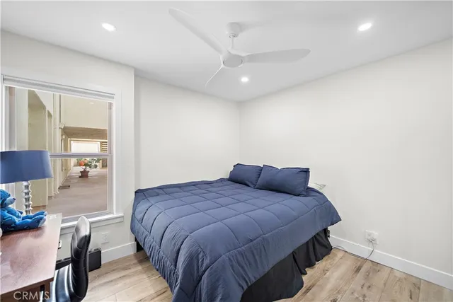 a bedroom with a bed and wooden floor
