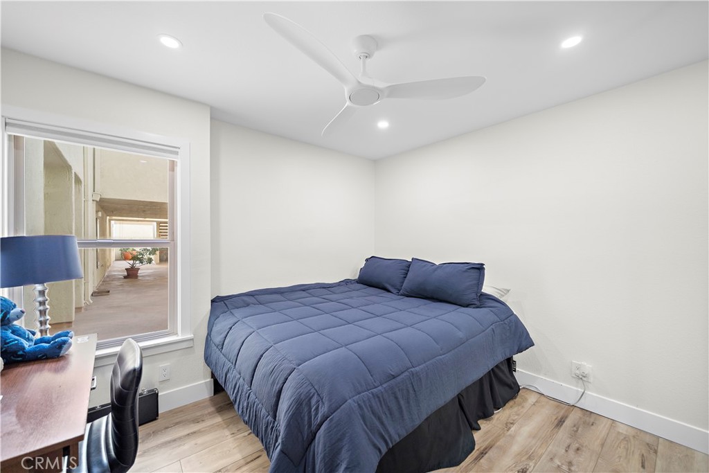 711 Pacific Coast Highway, Unit 330 Huntington Beach, CA 92648 - Photo 19 of 54 a bedroom with a bed and wooden floor