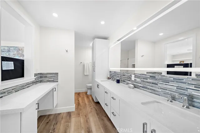 a large white kitchen with a stove and a sink