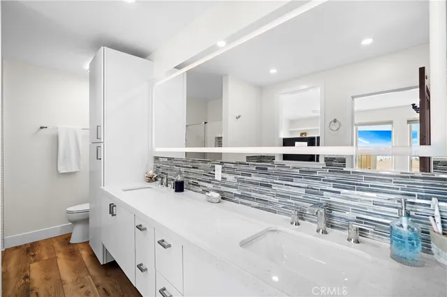 a bathroom with double vanity and a mirror