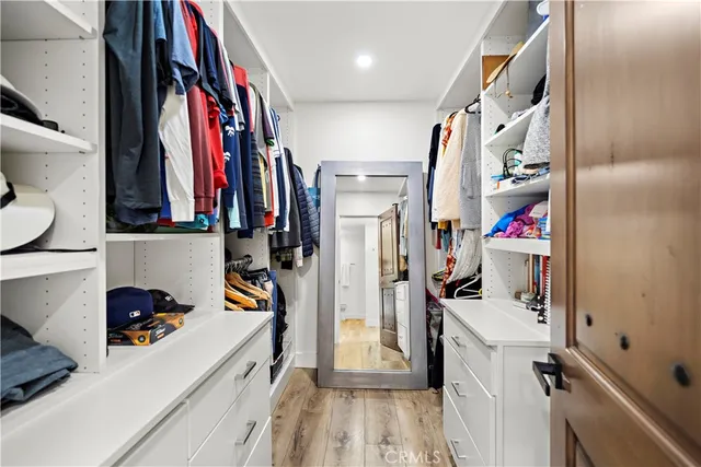 a view of walk in closet with clothes and shoes