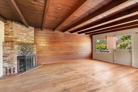 a view of an empty room with a fireplace and a window