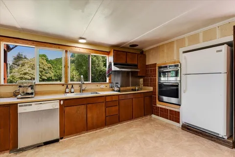 a kitchen with stainless steel appliances granite countertop a refrigerator sink and stove
