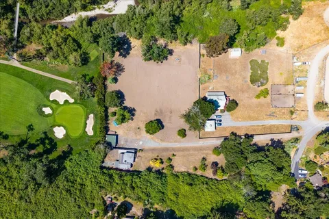 an aerial view of a house with a yard and lake view