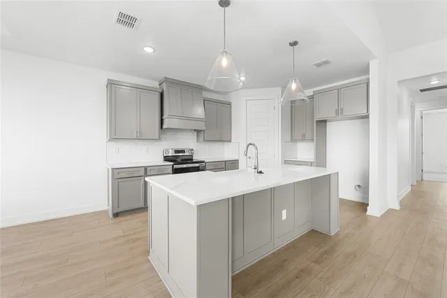 a kitchen with kitchen island a sink stainless steel appliances and cabinets
