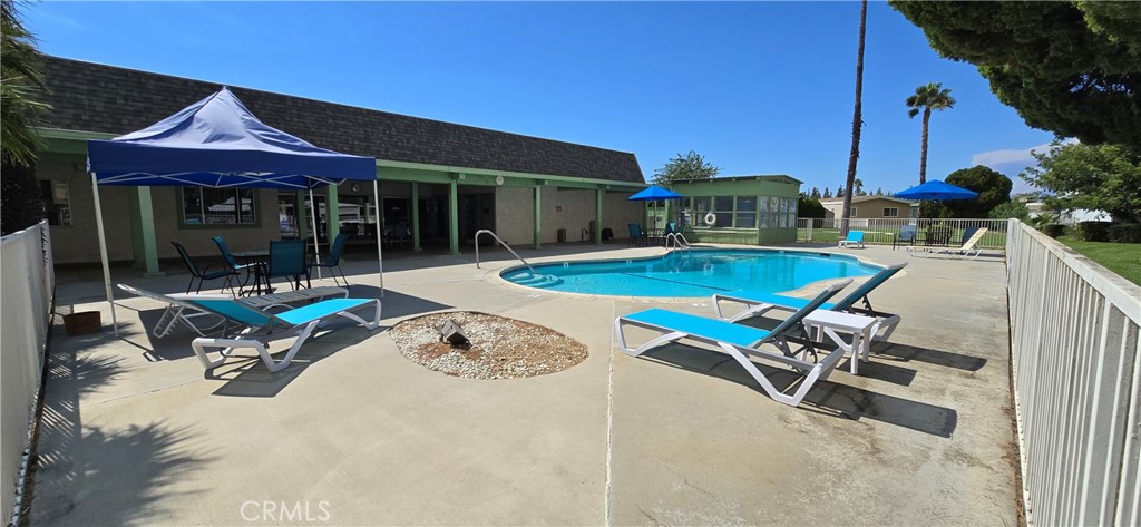 9391 California Avenue, Unit 80 Riverside, CA 92503 - Photo 21 of 28 a view of a patio with table and chairs under an umbrella with a small yard