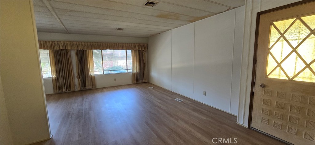 9391 California Avenue, Unit 80 Riverside, CA 92503 - Photo 6 of 28 wooden floor in an empty room with a window