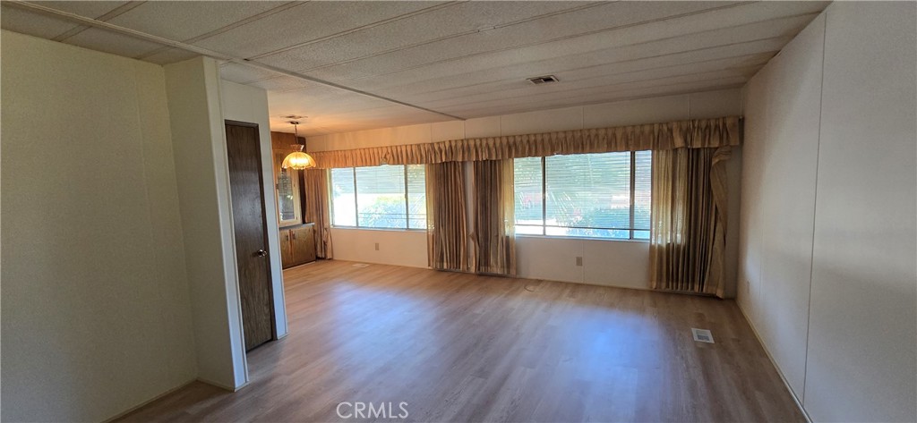 9391 California Avenue, Unit 80 Riverside, CA 92503 - Photo 7 of 28 a view of an empty room with wooden floor and a window