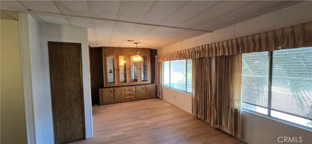 a view of a hallway with wooden floor and windows