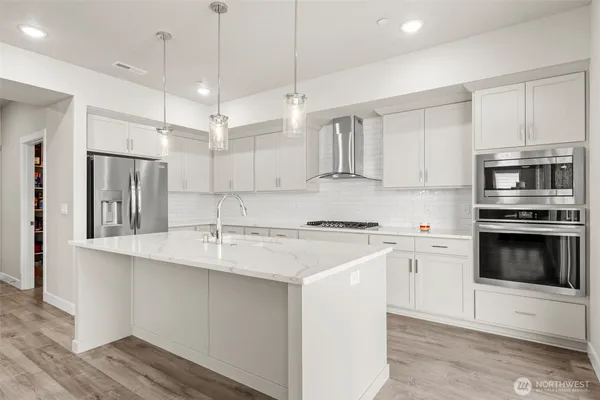 a kitchen with kitchen island a stove a sink and wooden floor