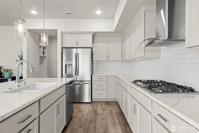 a kitchen with stainless steel appliances a refrigerator sink and cabinets