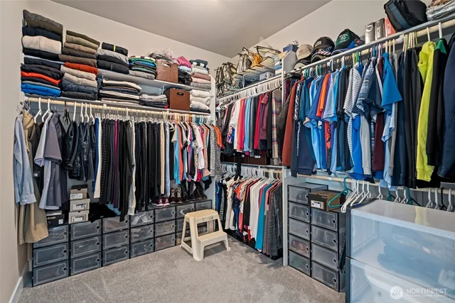 a view of walk in closet with clothes and shoes