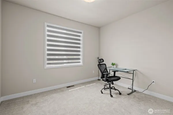 a view of a workspace with furniture and a window