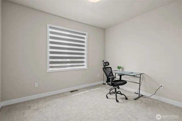 a view of a workspace with furniture and a window