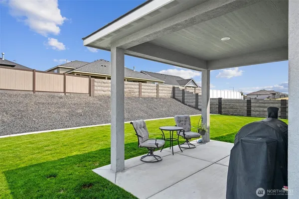 a view of a backyard with couches under an umbrella
