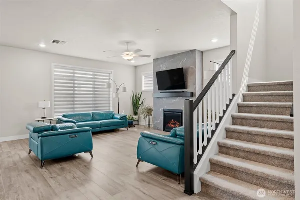 a living room with furniture a flat screen tv and a fireplace