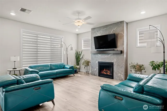 a living room with furniture a flat screen tv and a fireplace