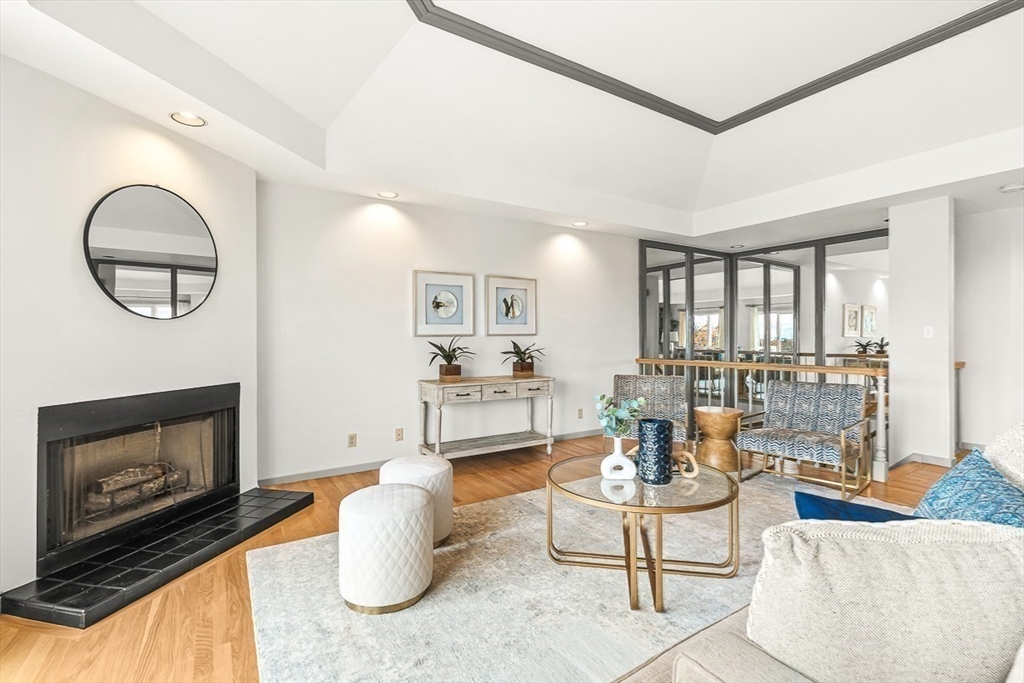 67 Algonquin Road, Unit 67 Newton, MA 02467 - Photo 8 of 38 a living room with furniture a fireplace and a floor to ceiling window