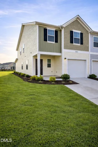 a view of kitchen and empty room with wooden floor