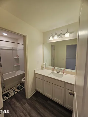 a view of a backyard with plants and large tree