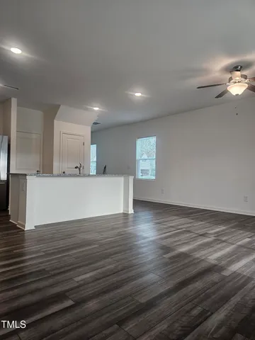 a large white kitchen with kitchen island a sink and a stove