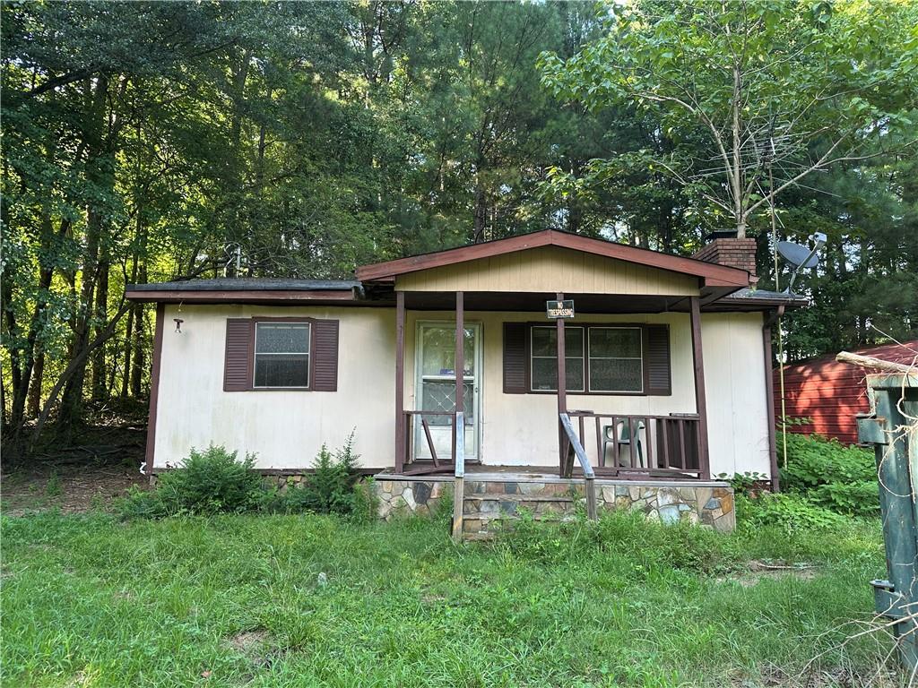 a view of a house with a yard and sitting area