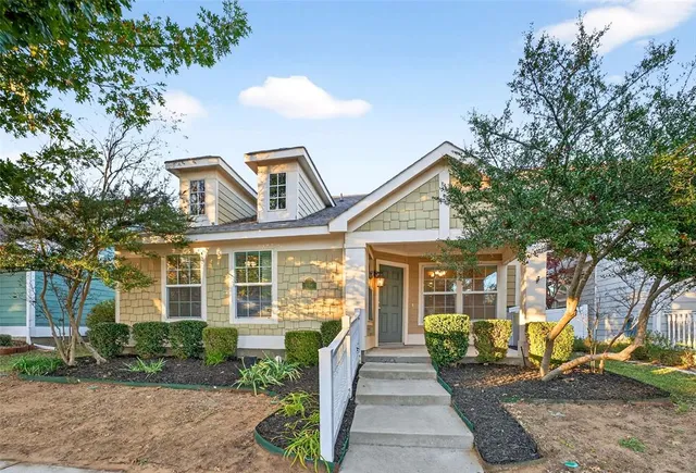 a front view of a house with a yard and potted plants
