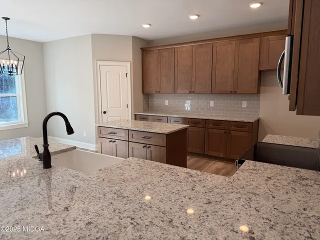 a kitchen with stainless steel appliances kitchen island sink refrigerator and cabinets