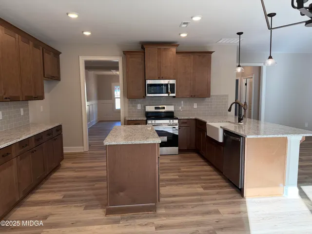 a kitchen with kitchen island a sink stainless steel appliances and cabinets