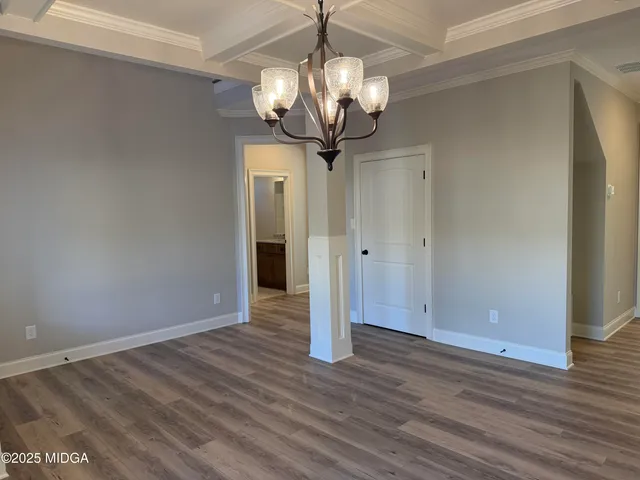 a view of a chandelier in big room with wooden floor