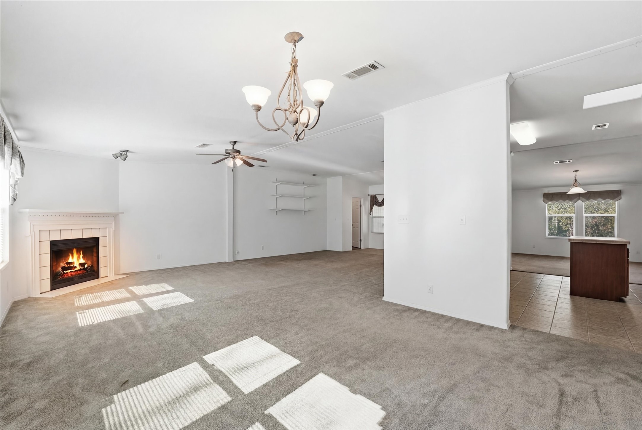 351 County Road 6501 Dayton, TX 77535 - Photo 7 of 29 a view of a livingroom with a fireplace a chandelier and windows