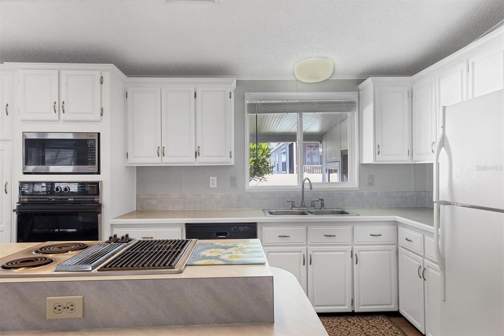 3502 Rita Place Ellenton, FL 34222 - Photo 12 of 46 a kitchen with granite countertop a stove a sink and a refrigerator