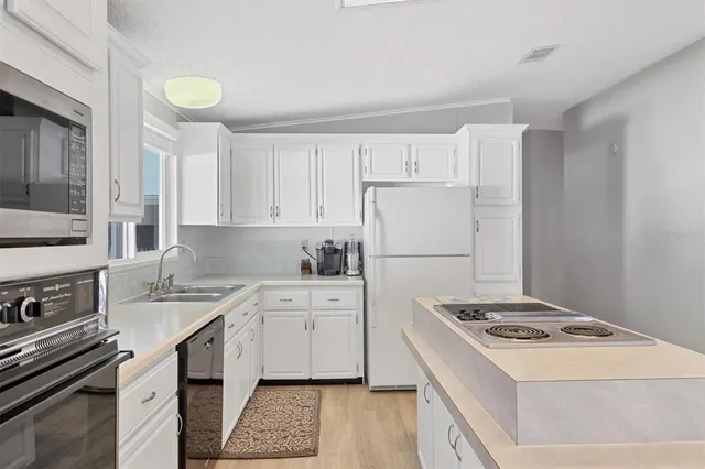 a kitchen with a stove a sink and a refrigerator