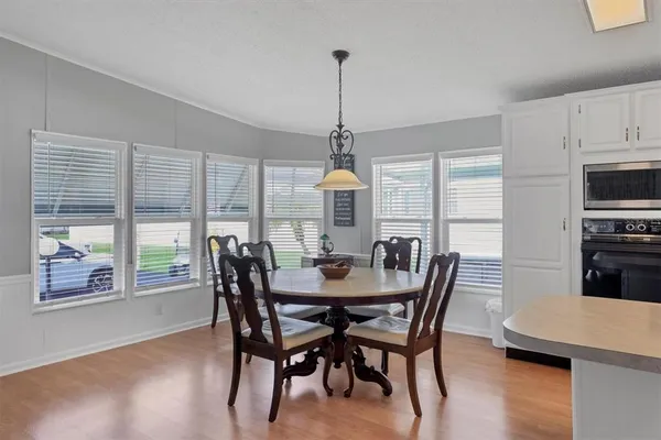 a dining room with furniture a chandelier and wooden floor