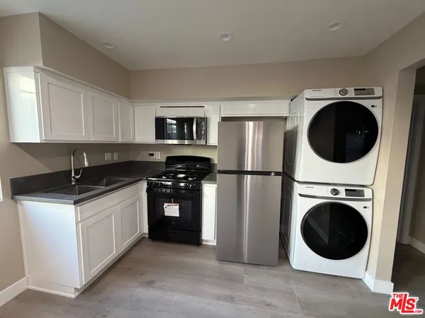a kitchen with stainless steel appliances granite countertop a stove a sink and a refrigerator