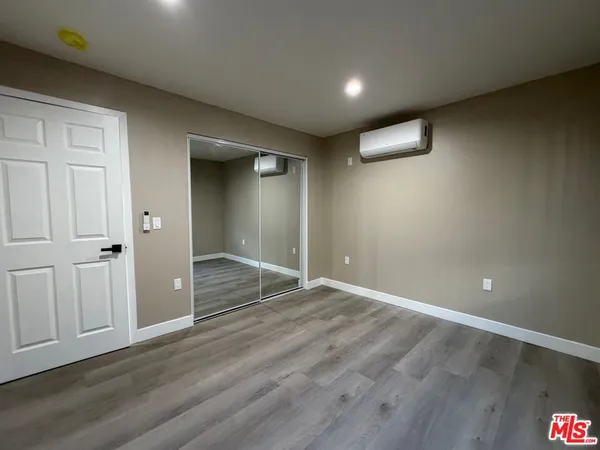 an empty room with wooden floor and closet