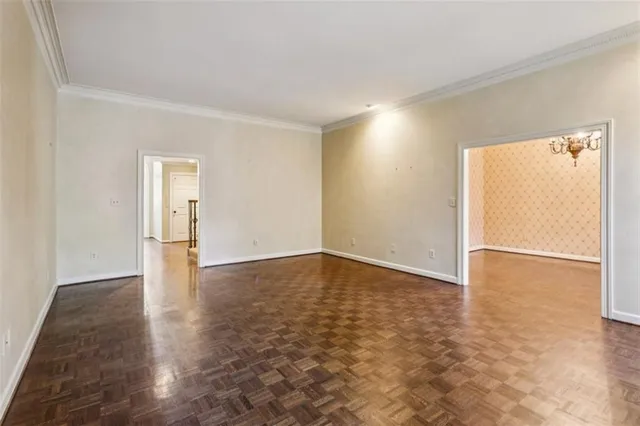 an empty room with windows fireplace and wooden floor