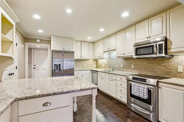 a kitchen with granite countertop cabinets stainless steel appliances and a sink