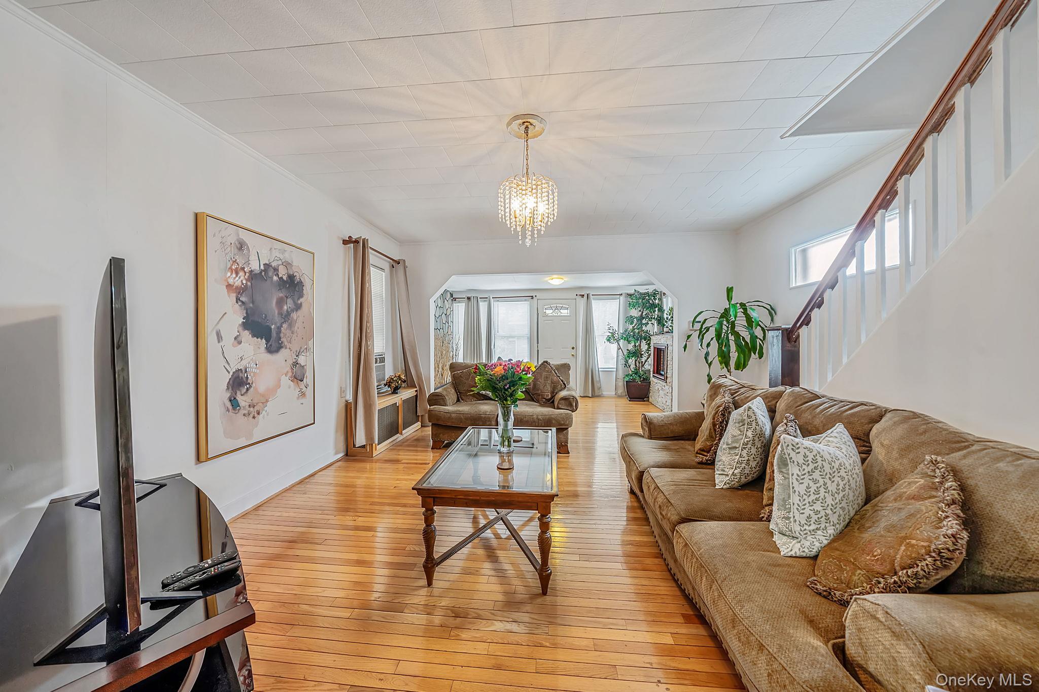 93-20 92nd Avenue Queens, NY 11421 - Photo 6 of 21 a living room with furniture a dining table and a chandelier