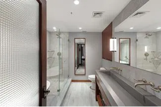 a bathroom with a granite countertop double vanity sink and a mirror