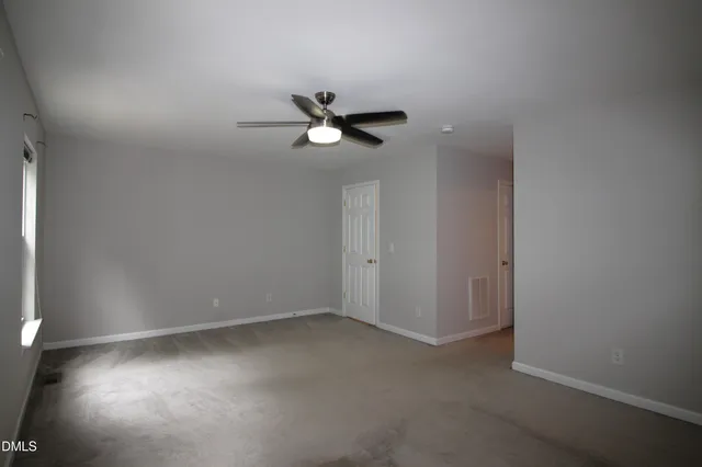 a view of room with a ceiling fan and a window